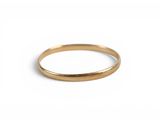 gros plan d'une bague en or sur fond blanc