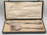 an antique silverware set in a case with a spoon and fork