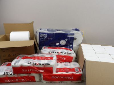 Des paquets de papier toilette et des rouleaux de papier toilette sont empilés par terre