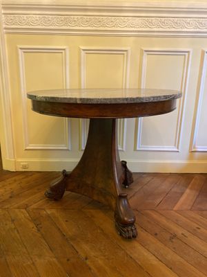 une photo d'une table en bois avec un plateau en marbre posée sur un parquet en bois massif