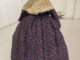 doll made from an old dress and a hat sitting on a white surface