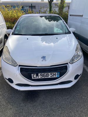 La voiture blanche est garée sur le parking, à côté de la camionnette blanche.