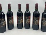 six bouteilles de vin sont alignées sur une table