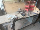 une photo d'un établi dans un atelier, avec des outils