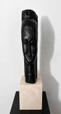 black sculpture of a woman ' s head on a black pedestal