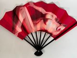 a red fan with a picture of a woman on it