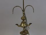 an antique brass oil lamp with a bird on top of it