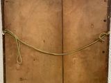 an old suitcase with a rope hanging from it ' s side