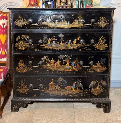 une commode noire sur laquelle est posé un tableau