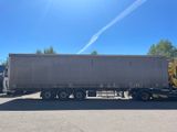 the semi truck is parked in the parking lot next to the building