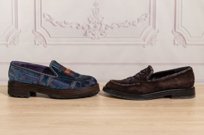two pairs of shoes sitting on a wooden floor next to a wall