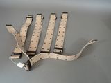 four pieces of leather strap with metal buckles on a gray surface