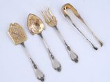 three silver spoons and a fork are sitting next to each other