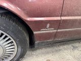 a red car that has been damaged and is parked on the side of the road