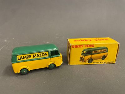 un petit bus jouet jaune et vert à côté d'une boîte, posé sur une surface grise