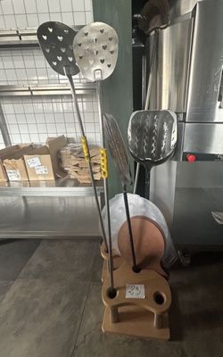 Plusieurs ustensiles de cuisine sont posés sur un présentoir dans un entrepôt