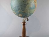 an old globe on a wooden stand with a white background