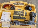 une mallette à outils jaune, contenant des outils, posée par terre