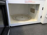 a microwave that is sitting on the floor with its door open
