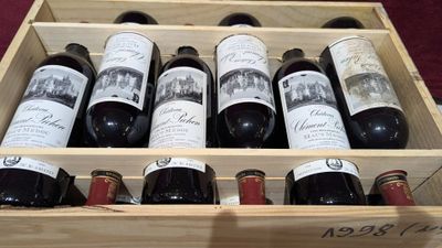 plusieurs bouteilles de vin dans un coffret en bois posé sur une table