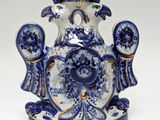 a blue and white vase with a bird on top of it