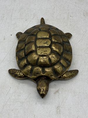 une tortue dorée sur un fond blanc, avec une inscription en chinois