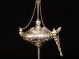 an antique silver plated incense holder with a chain around it