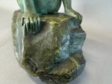 a statue of a monkey sitting on a rock
