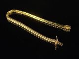 a gold chain with a cross charm on it