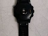 a black watch that is laying on a white surface