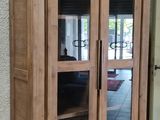 un meuble en bois avec des portes en verre dans une pièce