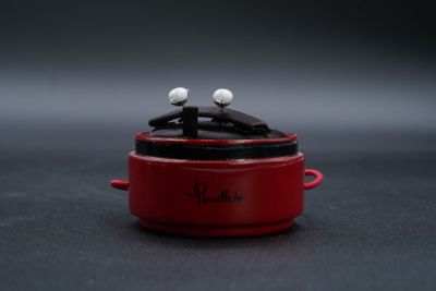 un petit pot rouge contenant deux boules blanches