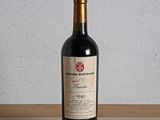 une bouteille de vin rouge posée sur une table en bois