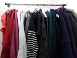 a lot of clothes hanging on a rack in a room