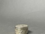an old silver box sitting on top of a gray surface