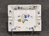 une assiette carrée décorée de fleurs et de feuilles bleues