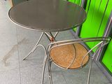 a small table and two chairs in front of a green wall