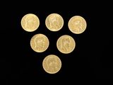 six gold coins are arranged in a triangle on a black background