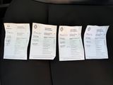 four papers are sitting on the back of a car seat