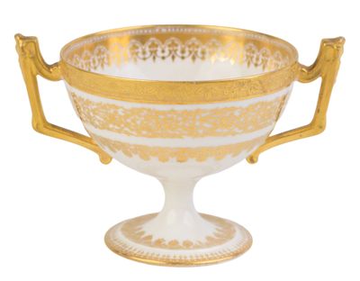 une tasse dorée et blanche avec des anses, posée sur un fond blanc