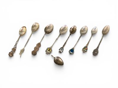 un ensemble de cuillères en argent et de cuillères à soupe posées sur une surface blanche