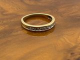 an image of a gold ring with black diamonds on a wooden table