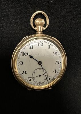 a gold pocket watch on a black surface