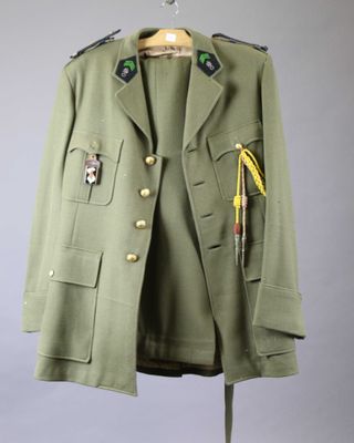 an army green jacket with a badge on the chest and a tie
