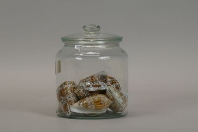 a glass jar filled with donuts covered in powdered sugar