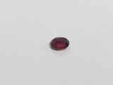 a red garnet stone on a white surface