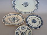 four blue and white plates and a platter on a table