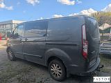 the back end of a grey van parked in a parking lot