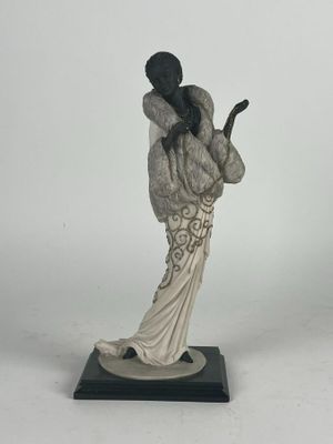 figurine représentant une femme en robe blanche tenant un téléphone portable