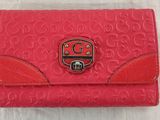 a red coach purse with a lock on the front